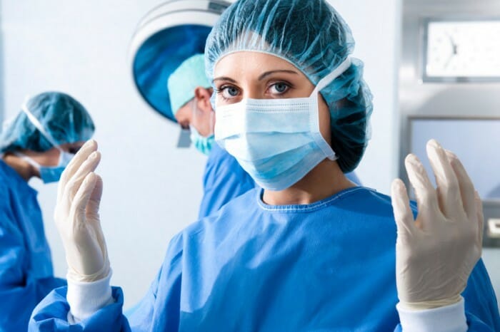 Una cirujana que opera en un paciente