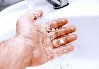 Remojar el área afectada en agua tibia y jabonosa puede ayudar a eliminar el súper pegamento de la piel